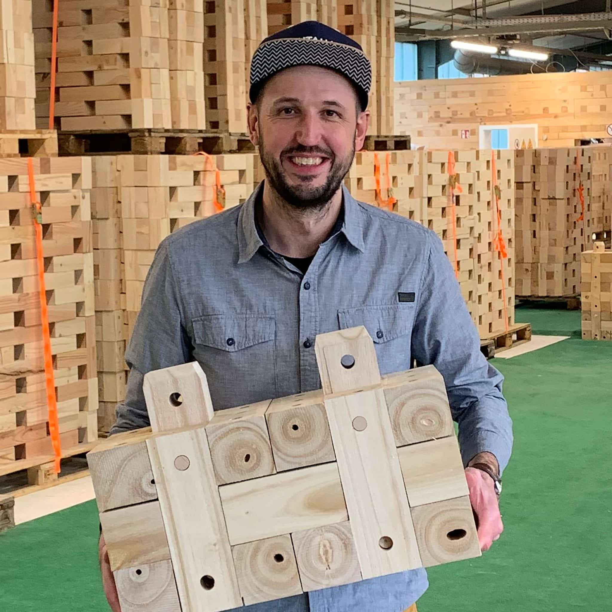 Organisationsentwickler Christian Klerner vor Holzbau im Stammwerk von Massivholzhaus Hersteller TRIQBRIQ